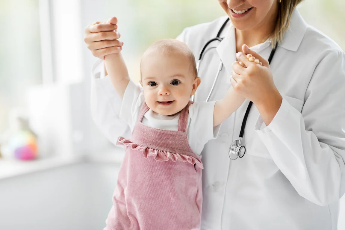 Consulta médica humanizada para bebês Bebê feliz sendo apoiado por médica durante consulta médica